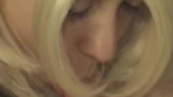 Wig-wearing hottie deepthroats a dog's dick on cam