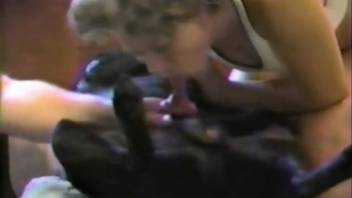 Naked lady performs deep oral on a canine's penis while her husband watches