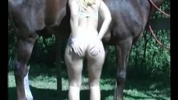 Blond-haired chick enjoying outdoor oral with a horse